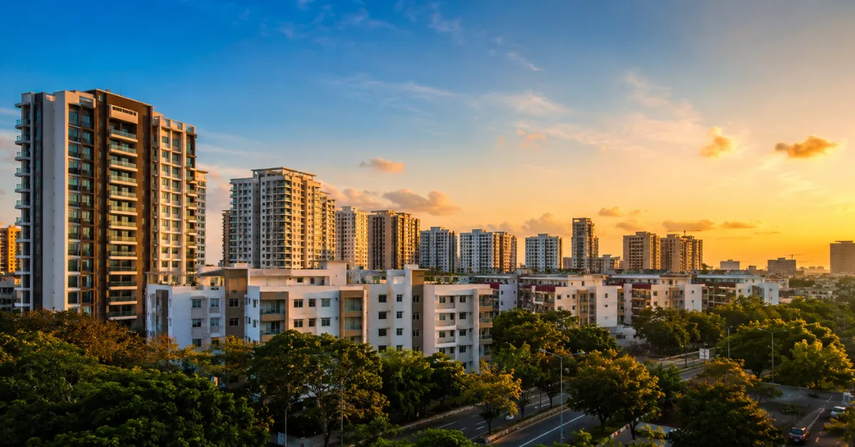 Best places to live in Chennai with modern apartments, green spaces, roads, and a vibrant urban skyline at sunset